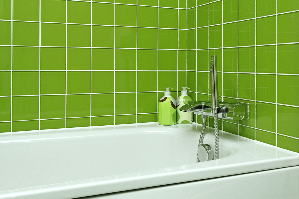 Bathtub with modern faucet in green bathroom