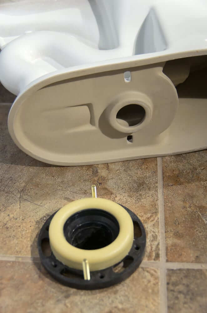 toilet lifted to show wax ring seal.