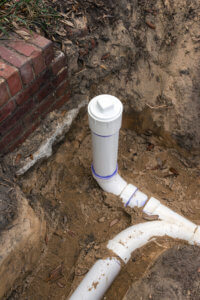 New PVC pipe sewer line and clean out installed in trench.