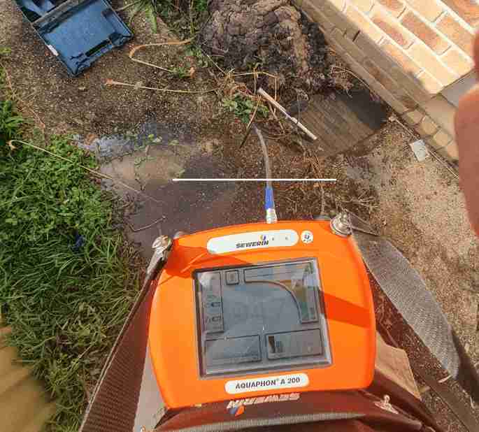 acoustic-leak-detection-equipment Acoustic leak detection device used by a plumber to locate hidden underground water leaks near a building.
