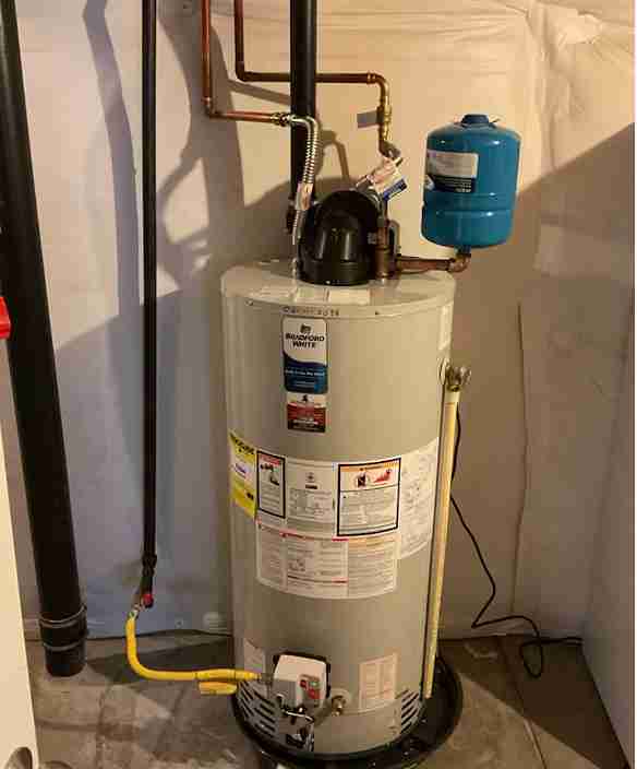 residential-water-heater-expansion-tank-installation A residential Bradford White water heater with a blue expansion tank and copper piping, professionally installed by New Flow Plumbing